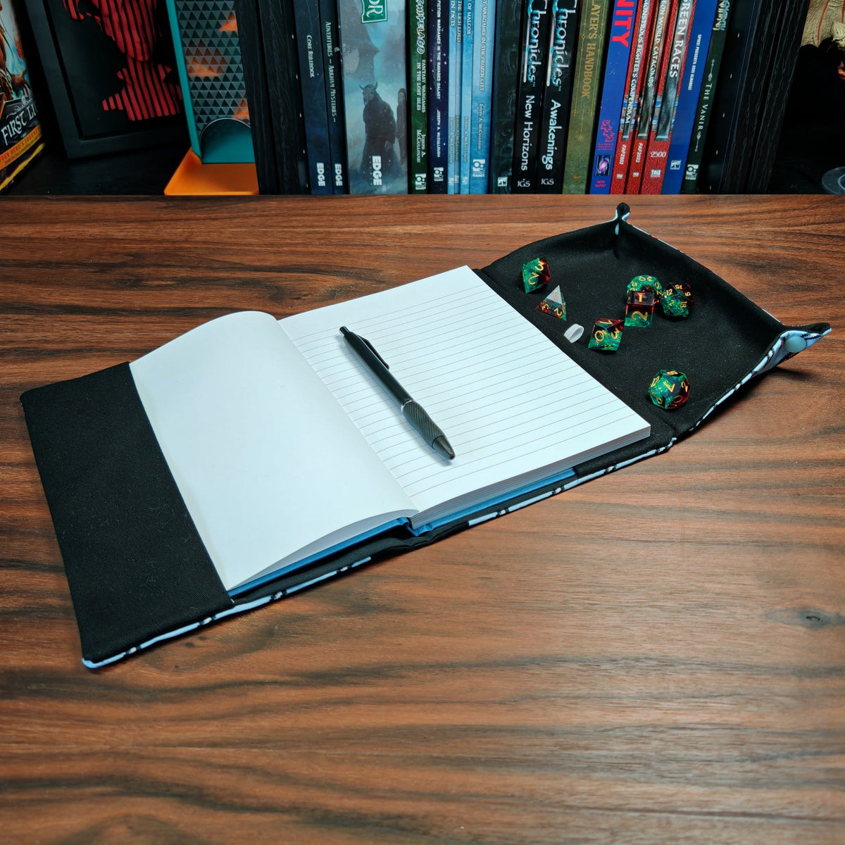 Angled view of gaming notebook with built-in dice tray and pen
